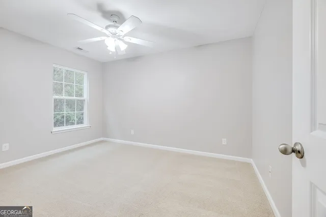 a view of an empty room with a ceiling fan