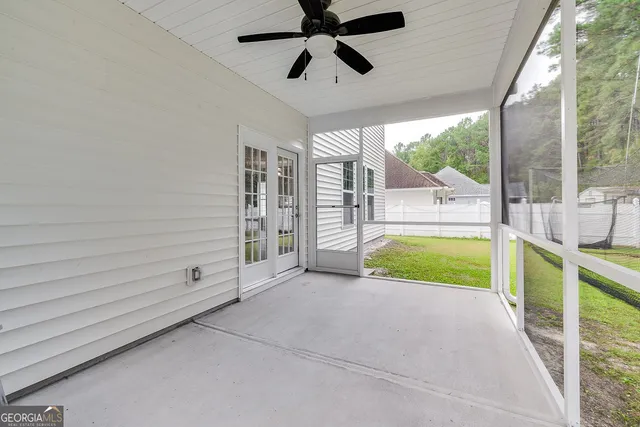 a view of a backyard with plants and large trees
