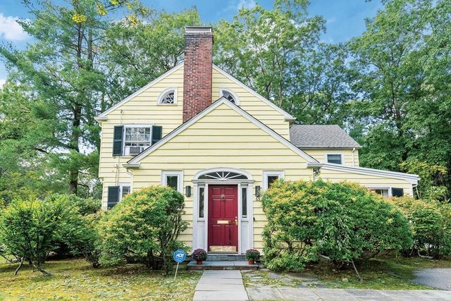 a view of a house with potted plants and large trees