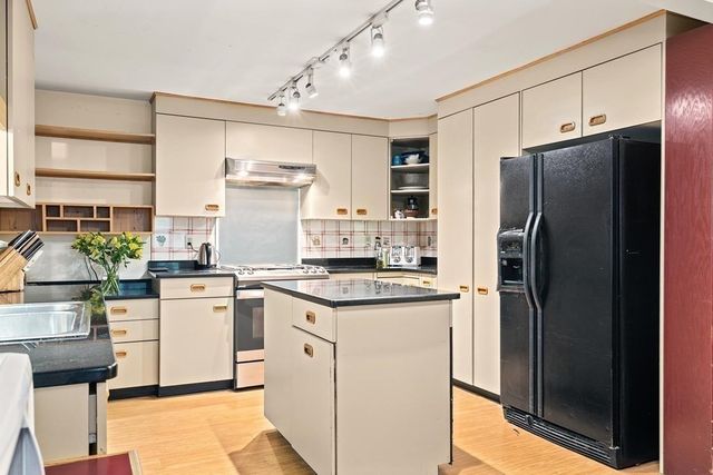 a kitchen with stainless steel appliances granite countertop a refrigerator and a stove top oven