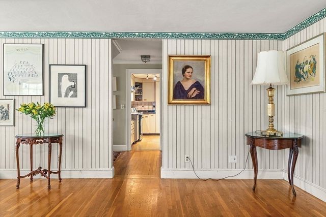 a view of a hallway with wooden floor and windows