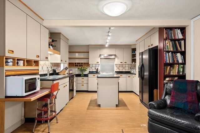 a kitchen with stainless steel appliances granite countertop a refrigerator a stove and a sink