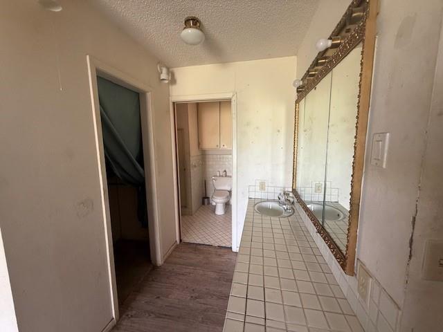 909 Railroad Street Rochester, TX 79544 - Photo 15 of 19 Hall featuring wood finished floors and a textured ceiling