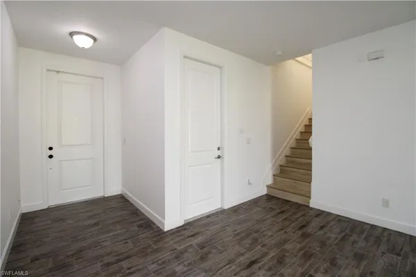 a view of a hallway with wooden floor and entryway