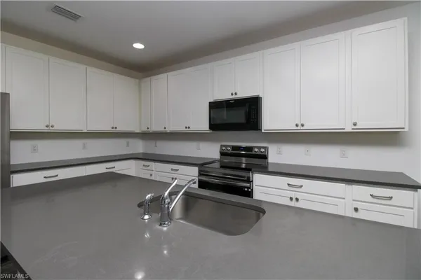 a kitchen with a sink a stove and cabinets