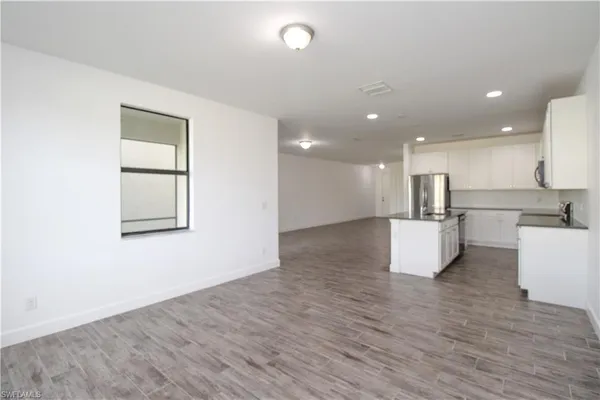 a view of kitchen with kitchen island microwave and wooden floor