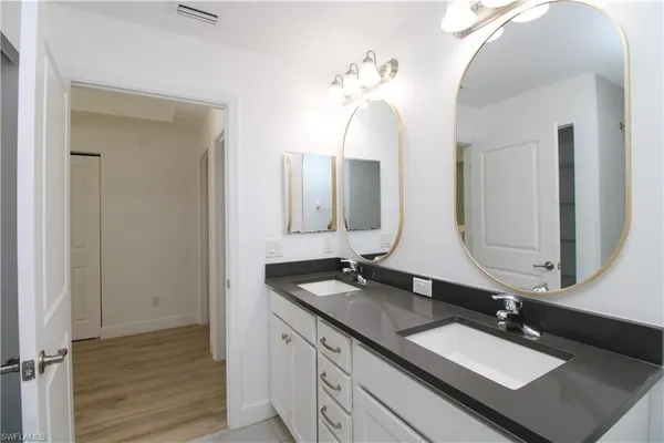 a bathroom with double vanity sinks and a mirror