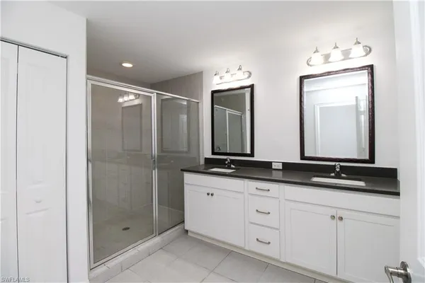 a bathroom with double sink and a mirror
