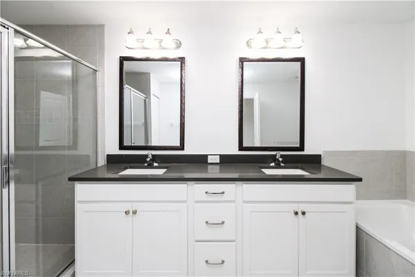 a bathroom with double vanity sinks and a mirror