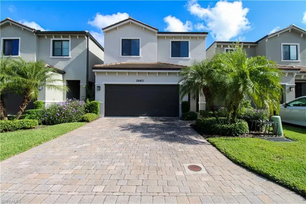 a front view of a house with a yard and potted plants