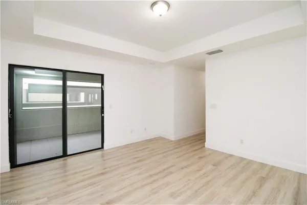 an empty room with wooden floor and door