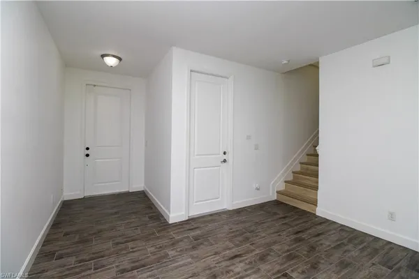 a view of a hallway with wooden floor and entryway