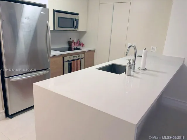 a large bed sitting in a bedroom next to a window