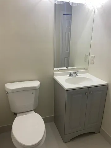 a white toilet sitting next to a bathroom sink