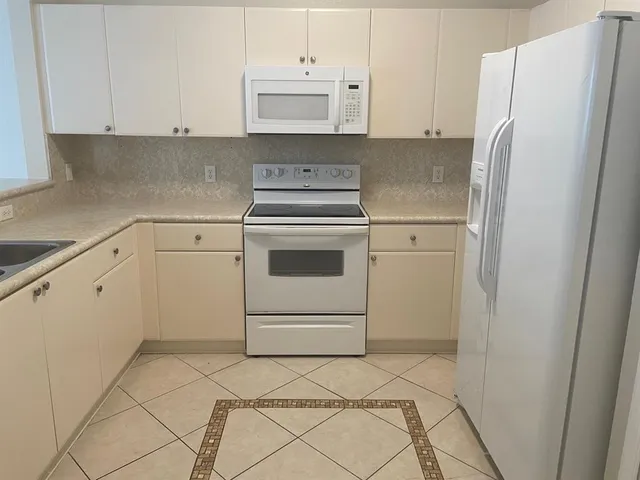 a kitchen with white cabinets and white stainless steel appliances