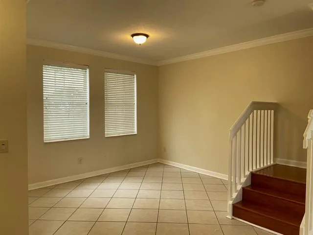 a view of an empty room with stairs and a floor to ceiling window