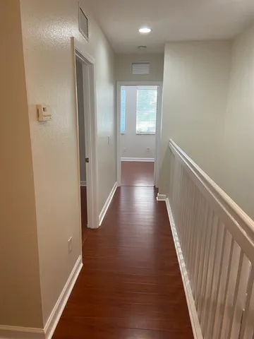a view of a hallway with wooden floor