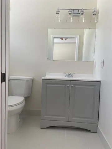 a bathroom with a sink a toilet and mirror