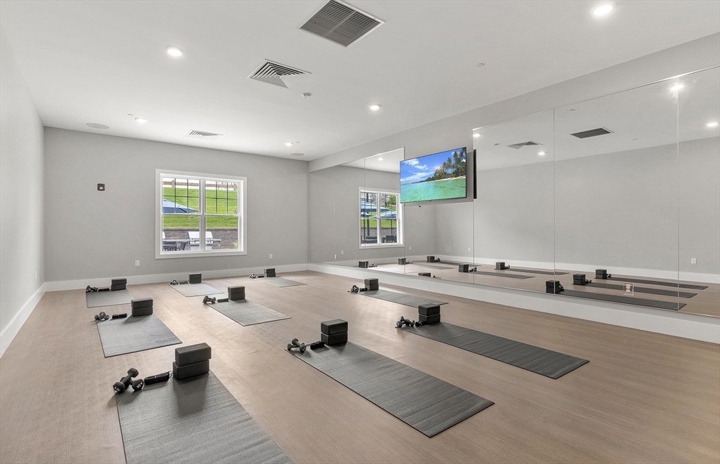 2 Codman Way, Unit 207 Westborough, MA 01581 - Photo 34 of 40 a living room with kitchen island furniture and a wooden floor