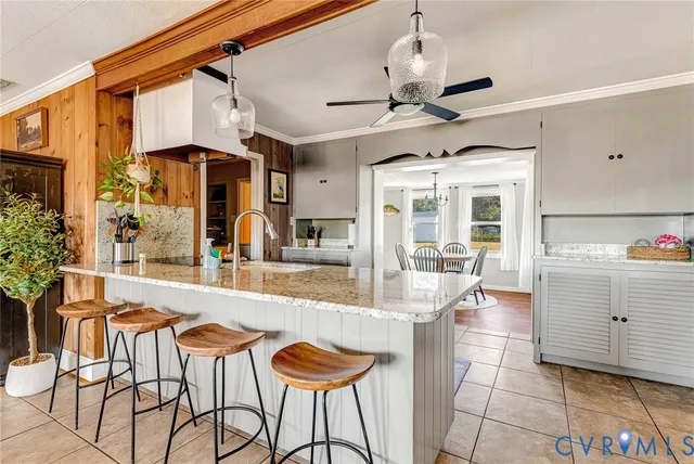 a dining hall with stainless steel appliances kitchen island granite countertop a table and chairs