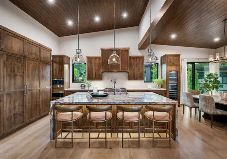 a kitchen with stainless steel appliances granite countertop a kitchen island a table and chairs