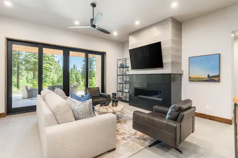 a living room with furniture a large window and a fireplace