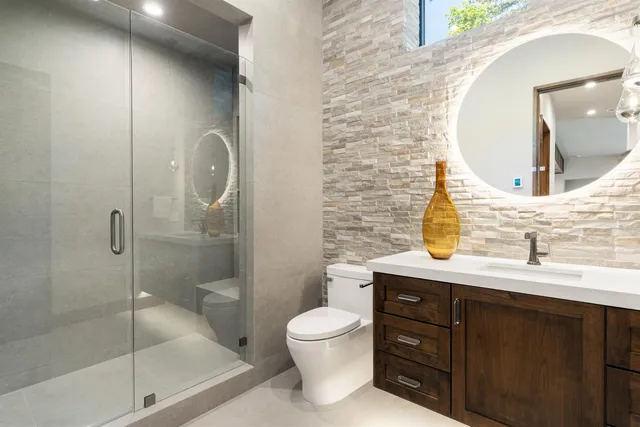 a bathroom with a granite countertop sink toilet a mirror and shower