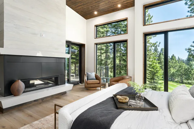 a living room with patio furniture and floor to ceiling windows