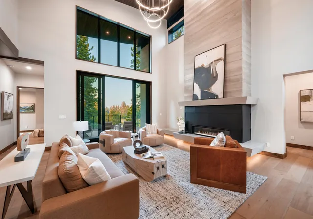 a living room with furniture a large window and a fireplace