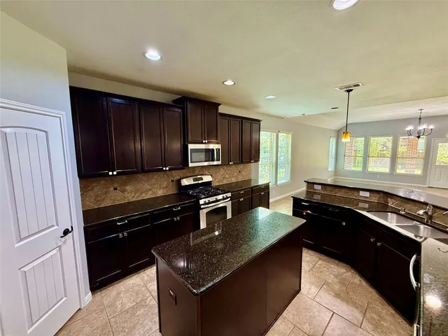 a kitchen with granite countertop stainless steel appliances and wooden cabinets