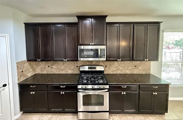 a kitchen with granite countertop stainless steel appliances and wooden cabinets