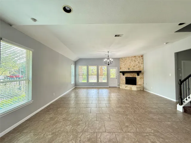 a view of empty room with a fireplace and windows