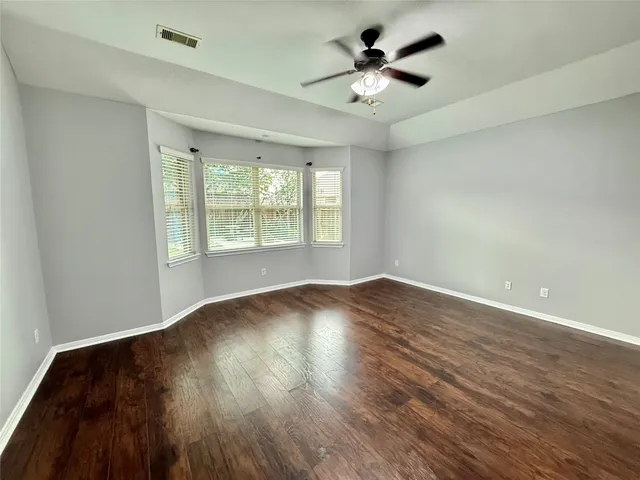 an empty room with wooden floor and chandelier
