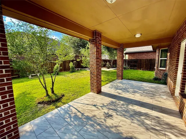 a view of backyard with table and chairs and a barbeque