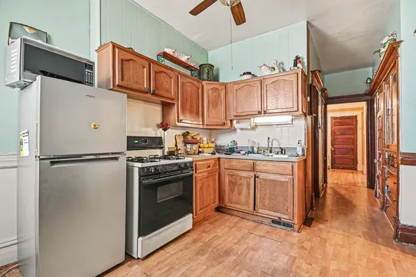 a kitchen with stainless steel appliances granite countertop a refrigerator a stove and a sink