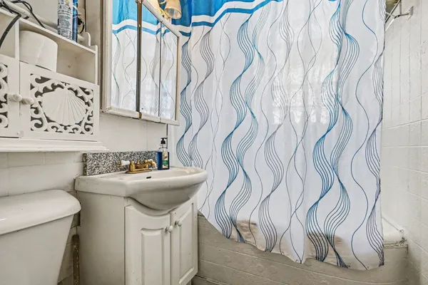 a bathroom with a sink and mirror with toilet