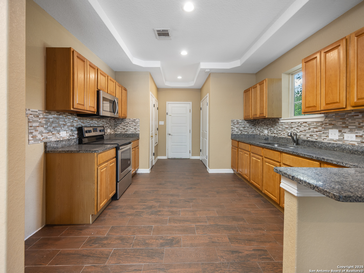 104 Viewpoint Drive Poteet, TX 78065 - Photo 7 of 23 a kitchen with stainless steel appliances granite countertop a stove a sink and a refrigerator