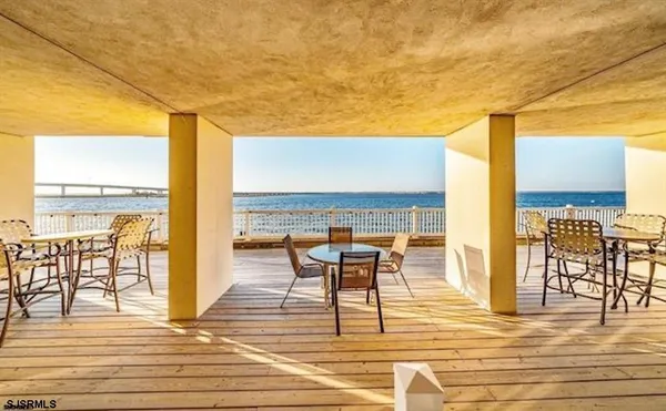 a view of a balcony with chairs and wooden floor
