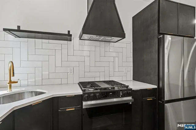 a kitchen with stainless steel appliances a sink stove and refrigerator