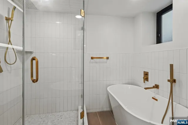 a bathroom with a tub a sink and shower