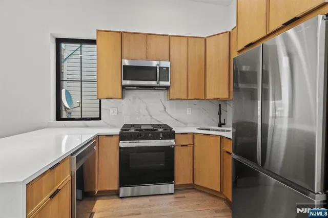 a kitchen with stainless steel appliances granite countertop a stove a refrigerator and a sink