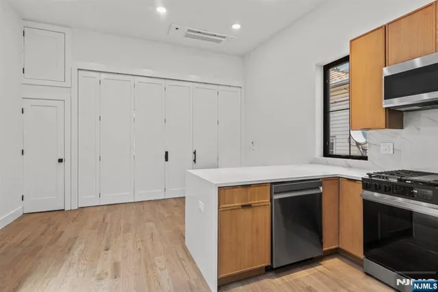 a kitchen with white cabinets and sink