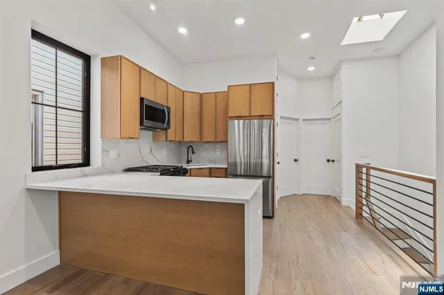 a kitchen with a refrigerator a stove and a microwave