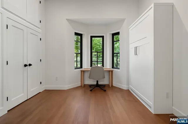 a view of a room with wooden floor and a window