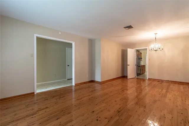 an empty room with wooden floor and window