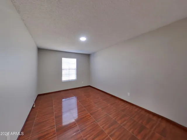 a view of an empty room with wooden floor and closet
