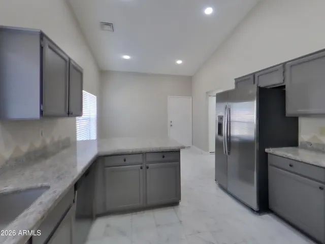 a kitchen with stainless steel appliances granite countertop a refrigerator and a sink