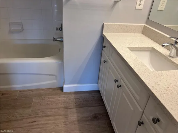 a bathroom with a tub sink and vanity