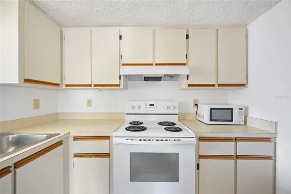 a kitchen with a stove cabinets and white appliances