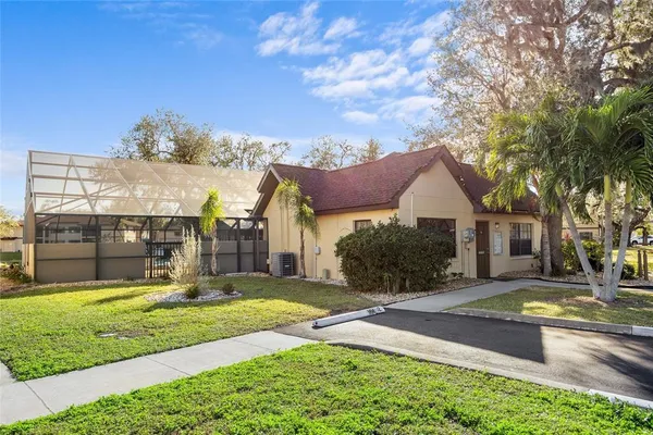 a front view of a house with a yard and potted plants